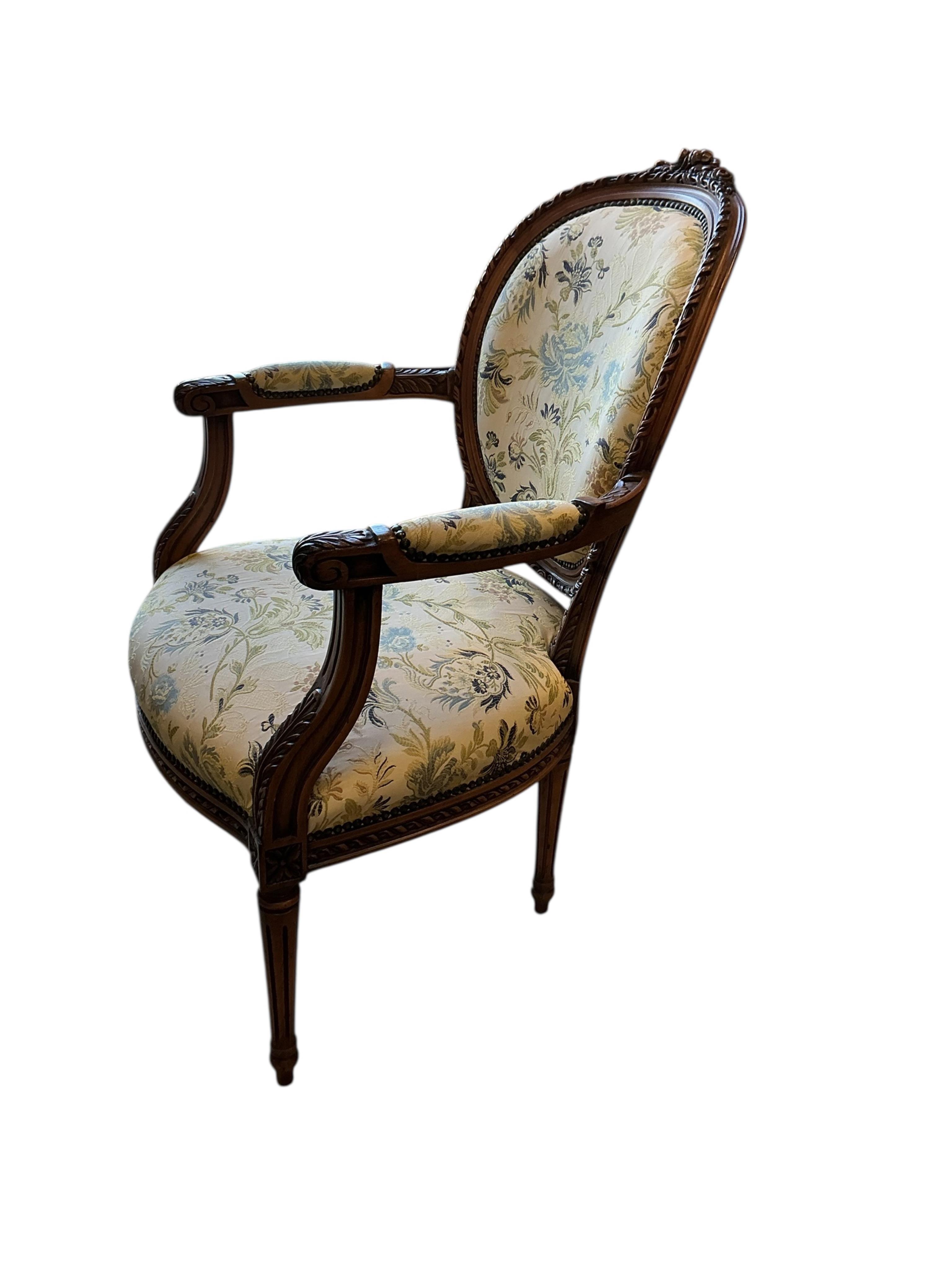 A reproduction Louis XVI style carved beech upholstered open armchair, width 65cm, depth 54cm, height 94cm
